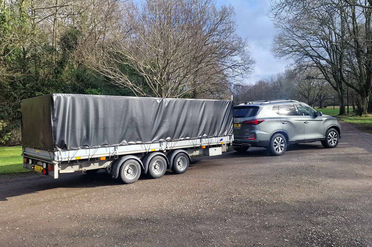 Car towing a large tri-axle trailer
